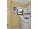 Practical laundry room with washer, dryer, storage cabinets, and a window at 7218 Darlington St, Englewood, FL 34224