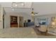 Open-concept living room featuring a bay window, ceiling fan, and dark wood entertainment center at 7218 Darlington St, Englewood, FL 34224