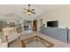 Cozy living room with vaulted ceilings, ceiling fan, and a view of the kitchen and outdoor patio at 7218 Darlington St, Englewood, FL 34224