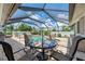 Covered patio area with comfortable seating, a dining table, and scenic views of the screened-in pool and backyard at 7218 Darlington St, Englewood, FL 34224