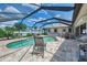 Outdoor enjoyment awaits in the screened-in pool area with seating, lush greenery, and a grill at 7218 Darlington St, Englewood, FL 34224