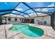Relax in the screened-in pool area with a lounge chair, built-in steps, and beautiful patio surroundings at 7218 Darlington St, Englewood, FL 34224