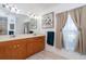 Bright bathroom featuring a double vanity, attractive mirror and cabinets, and calming neutral colors at 7376 Stetson Ln, Port Charlotte, FL 33981