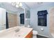 Bathroom features a large mirror, vanity with sink, toilet, window, and tiled shower and walls at 7376 Stetson Ln, Port Charlotte, FL 33981