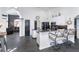 Kitchen featuring a black island, modern appliances, seating, and an archway leading to a living room at 7376 Stetson Ln, Port Charlotte, FL 33981