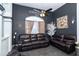 A cozy living room featuring dark walls, comfortable seating, ceiling fan, and natural light at 7376 Stetson Ln, Port Charlotte, FL 33981