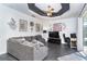 Spacious living room with a gray sofa, a ceiling fan, decorative artwork, and a large television at 7376 Stetson Ln, Port Charlotte, FL 33981