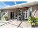 Inviting covered patio with a dining set, lush plants, and views of the landscaped backyard at 7376 Stetson Ln, Port Charlotte, FL 33981