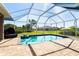Inviting screened-in pool area with lush greenery, perfect for enjoying the outdoors at 7376 Stetson Ln, Port Charlotte, FL 33981