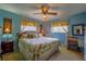 Cozy bedroom featuring a comfortable queen-sized bed with floral-patterned bedding and matching curtains at 7437 Bass St, Englewood, FL 34224