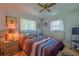 Inviting bedroom featuring a queen-sized bed, soft lighting, and windows that allow in natural light at 7437 Bass St, Englewood, FL 34224