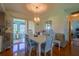 Elegant dining area with hardwood floors, a white dining set, and a view into a cozy sunroom at 7437 Bass St, Englewood, FL 34224