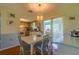 Bright dining area featuring hardwood floors, a white table set, and an open view into the kitchen and patio at 7437 Bass St, Englewood, FL 34224
