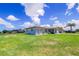 Well-maintained single-story home with a large, green lawn and light blue exterior under a clear blue sky at 7437 Bass St, Englewood, FL 34224