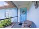 Charming entrance featuring a light blue front door with a decorative wreath and a cozy wicker chair at 7437 Bass St, Englewood, FL 34224