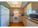 A charming kitchen with tan colored cabinets and stainless-steel appliances, perfect for creating delicious meals at 7437 Bass St, Englewood, FL 34224