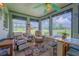 Cozy sunroom with a colorful rug, comfortable chairs, and a dining table set in front of large windows at 7437 Bass St, Englewood, FL 34224