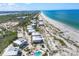 Panoramic aerial view of beachfront property featuring pristine white sand, turquoise waters, and beautifully landscaped condos at 7486 Palm Island Dr # 2413, Boca Grande, FL 33921
