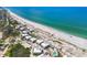 An aerial view showcasing beachfront property with white rooftops and a pool, set against turquoise waters at 7486 Palm Island Dr # 2413, Boca Grande, FL 33921