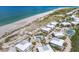 Aerial view of coastal homes with pools and tennis courts, close to the sandy beach and ocean at 7486 Palm Island Dr # 2413, Boca Grande, FL 33921
