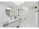Bright bathroom featuring a glass shower, modern vanity, and round mirror at 7486 Palm Island Dr # 2413, Boca Grande, FL 33921