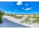 Expansive beachfront property featuring soft white sand and natural vegetation under a bright blue sky at 7486 Palm Island Dr # 2413, Boca Grande, FL 33921