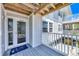 Inviting entryway featuring a glass door and sidelights, leading to an upper-level beach house with a cozy deck at 7486 Palm Island Dr # 2413, Boca Grande, FL 33921