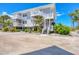 Two-story beach home with white railings, stairs, and lush tropical landscaping offering a relaxed coastal feel at 7486 Palm Island Dr # 2413, Boca Grande, FL 33921