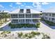 Aerial view of a condo building with spacious screened balconies and pristine landscaping nestled on the beach at 7486 Palm Island Dr # 2413, Boca Grande, FL 33921