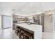 Bright kitchen featuring a large island with seating, stainless steel appliances, and open shelving at 7486 Palm Island Dr # 2413, Boca Grande, FL 33921