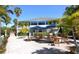 Enjoy outdoor dining on the patio with tables, chairs and shade umbrellas near lush tropical landscaping at 7486 Palm Island Dr # 2413, Boca Grande, FL 33921
