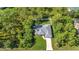 Aerial view of a beautiful single Gathering home featuring a large driveway, well manicured lawn, and mature trees at 7933 Minardi St, North Port, FL 34291