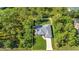 Aerial view of a beautiful single Gathering home featuring a large driveway, well manicured lawn, and mature trees at 7933 Minardi St, North Port, FL 34291