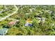 Aerial view of a charming single Gathering home, surrounded by mature trees in a quiet residential neighborhood at 7933 Minardi St, North Port, FL 34291
