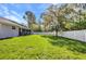 Spacious backyard with lush green grass and a white vinyl fence, ideal for outdoor activities at 7933 Minardi St, North Port, FL 34291