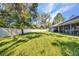 Expansive backyard with a well-maintained lawn, mature trees, and a white vinyl fence at 7933 Minardi St, North Port, FL 34291