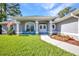 Charming home featuring a well-manicured lawn and inviting porch with blue chairs and an American flag at 7933 Minardi St, North Port, FL 34291