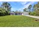 Attractive single-story home with a lush green lawn, mature trees, and a well-maintained driveway at 7933 Minardi St, North Port, FL 34291