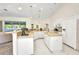 Open kitchen boasts white cabinetry, a kitchen island, recessed lighting, and tiled flooring at 7933 Minardi St, North Port, FL 34291