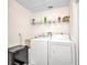 Bright laundry room featuring a washer, dryer, utility sink and ample shelving for storage at 7933 Minardi St, North Port, FL 34291
