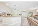 Bright and airy living room features white cabinets and breakfast bar open to the entryway and sitting room at 7933 Minardi St, North Port, FL 34291
