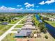 An aerial view of neighborhood homes along the water with lush vegetation and blue skies at 926 Boundary Blvd, Rotonda West, FL 33947