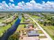 Aerial view of a canal-front home features a pool and meticulous landscaping in a residential neighborhood at 926 Boundary Blvd, Rotonda West, FL 33947