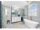 Bright bathroom featuring a standalone tub, glass-enclosed shower, and dual sink vanity with modern fixtures at 926 Boundary Blvd, Rotonda West, FL 33947