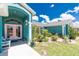 Charming home entrance features beautiful landscaping, pink front door, and inviting porch decor at 926 Boundary Blvd, Rotonda West, FL 33947