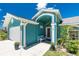 Home exterior shows front entrance with bench, blue paint, white trim, and a lushly landscaped yard at 926 Boundary Blvd, Rotonda West, FL 33947