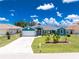 The home features a manicured lawn, mature landscaping, and a spacious driveway at 926 Boundary Blvd, Rotonda West, FL 33947