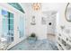 Welcoming home foyer with bright white doors and a stylish accent chest set upon the gorgeous blue tiled floors at 926 Boundary Blvd, Rotonda West, FL 33947