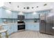 Well-equipped kitchen with stainless steel appliances, light blue cabinetry, and modern countertops at 926 Boundary Blvd, Rotonda West, FL 33947