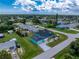 Aerial view of a turquoise home with beautiful landscaping and a quiet residential neighborhood at 9457 Heartwellville Ave, Englewood, FL 34224
